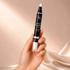 Makeup remover pen held in a hand against a beige background